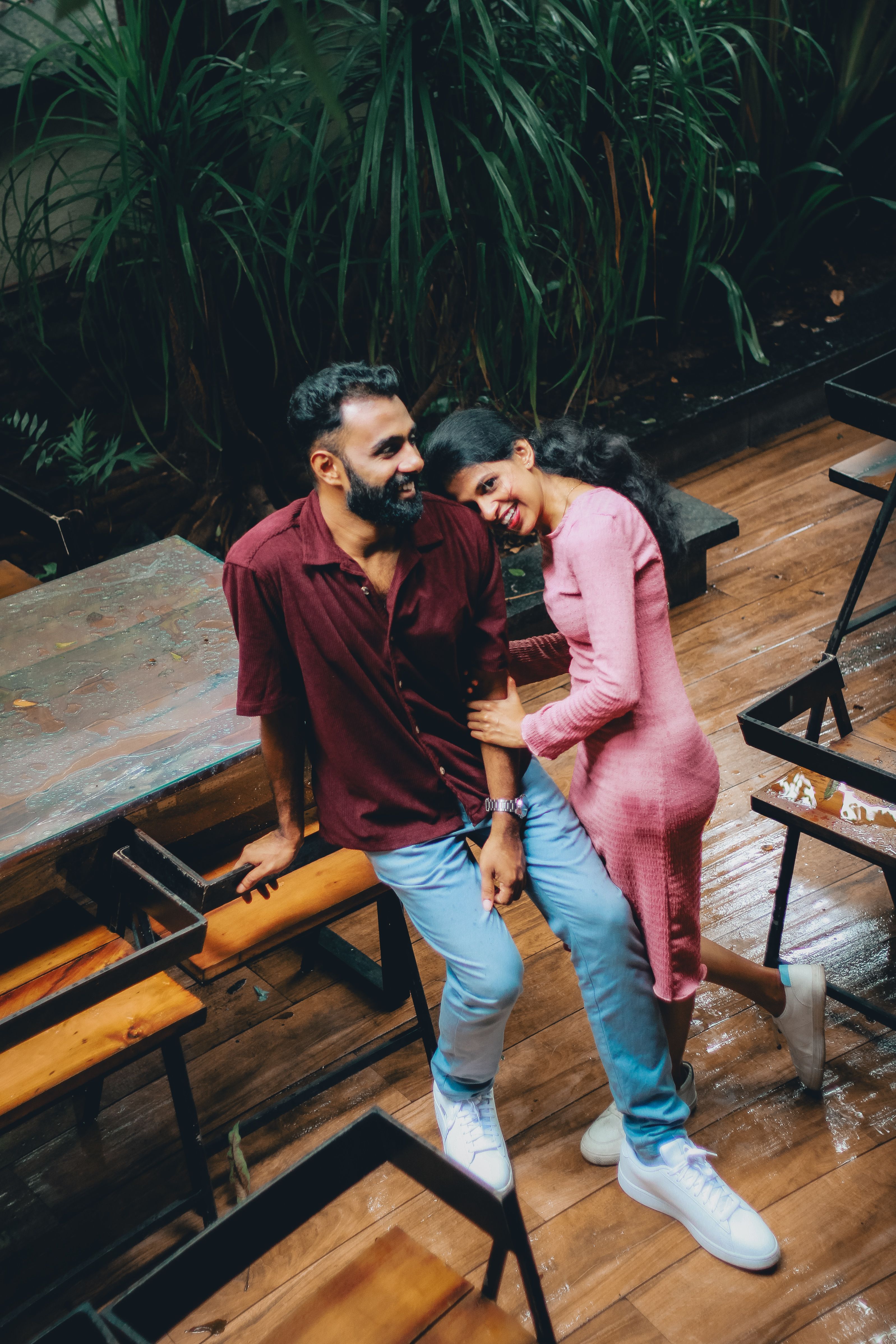Couple enjoying leisure time in a cozy outdoor setting, surrounded by lush greenery.