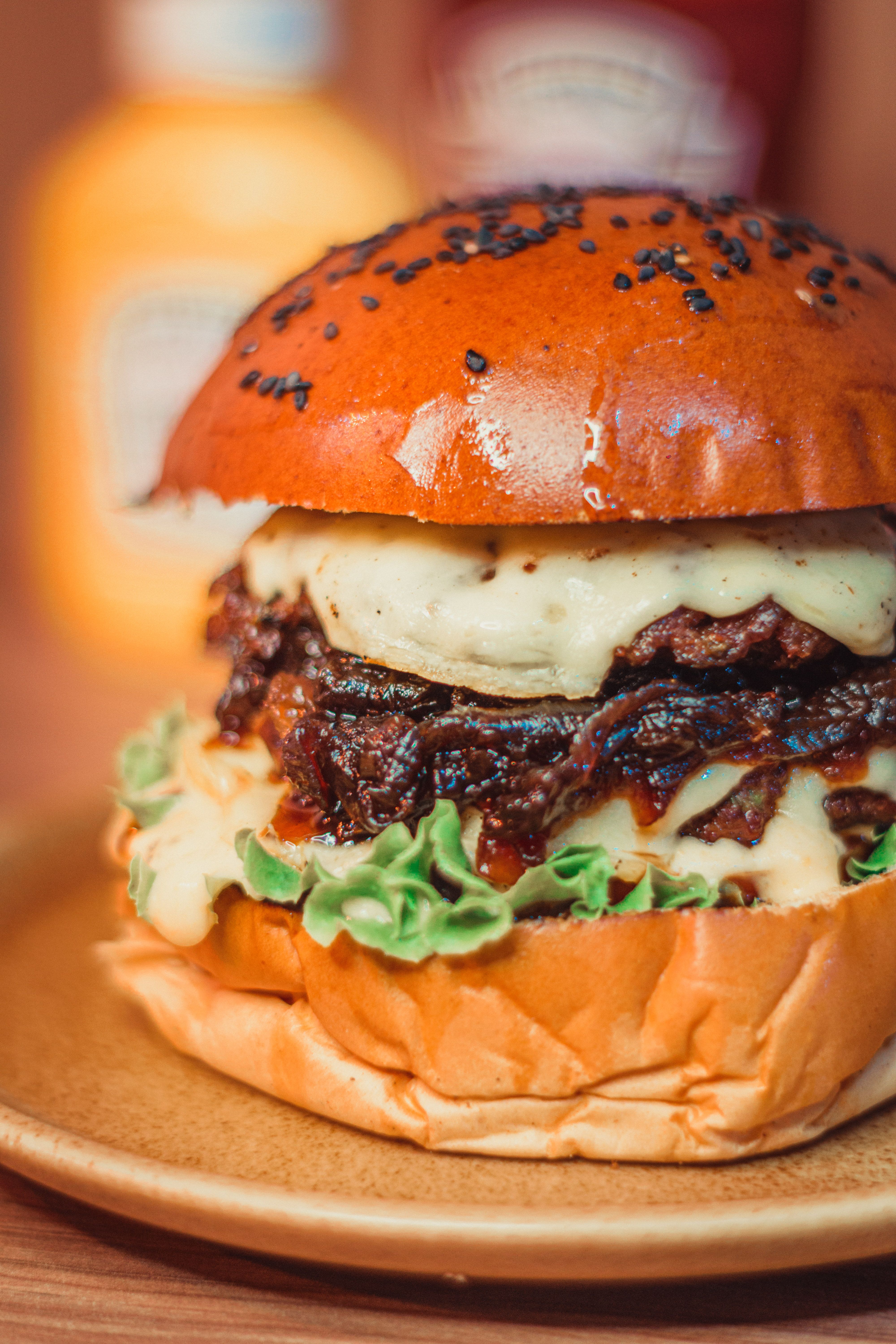 Close-up of a delicious gourmet cheeseburger with toppings on a plate.