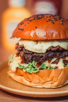 Close-up of a delicious gourmet cheeseburger with toppings on a plate.