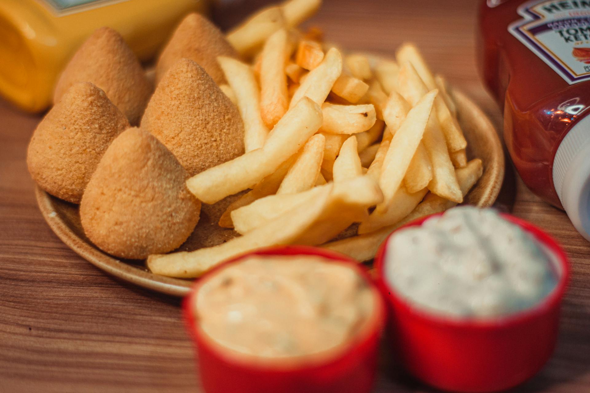 Delicious croquettes and fries served with dips and ketchup, perfect for a snack.