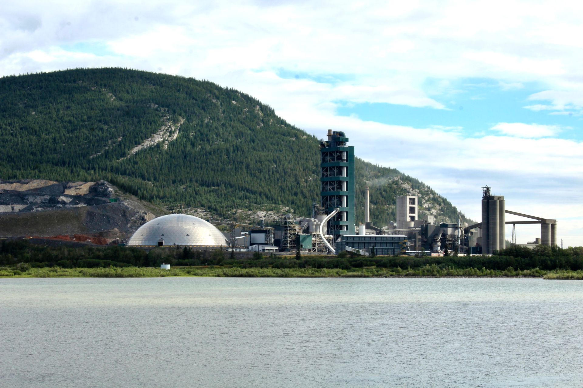 A large industrial plant with a mountain in the background