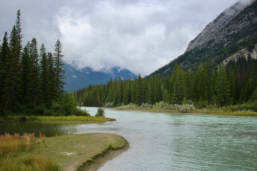 Serene river scene with mountains and trees, perfect for travel inspiration.