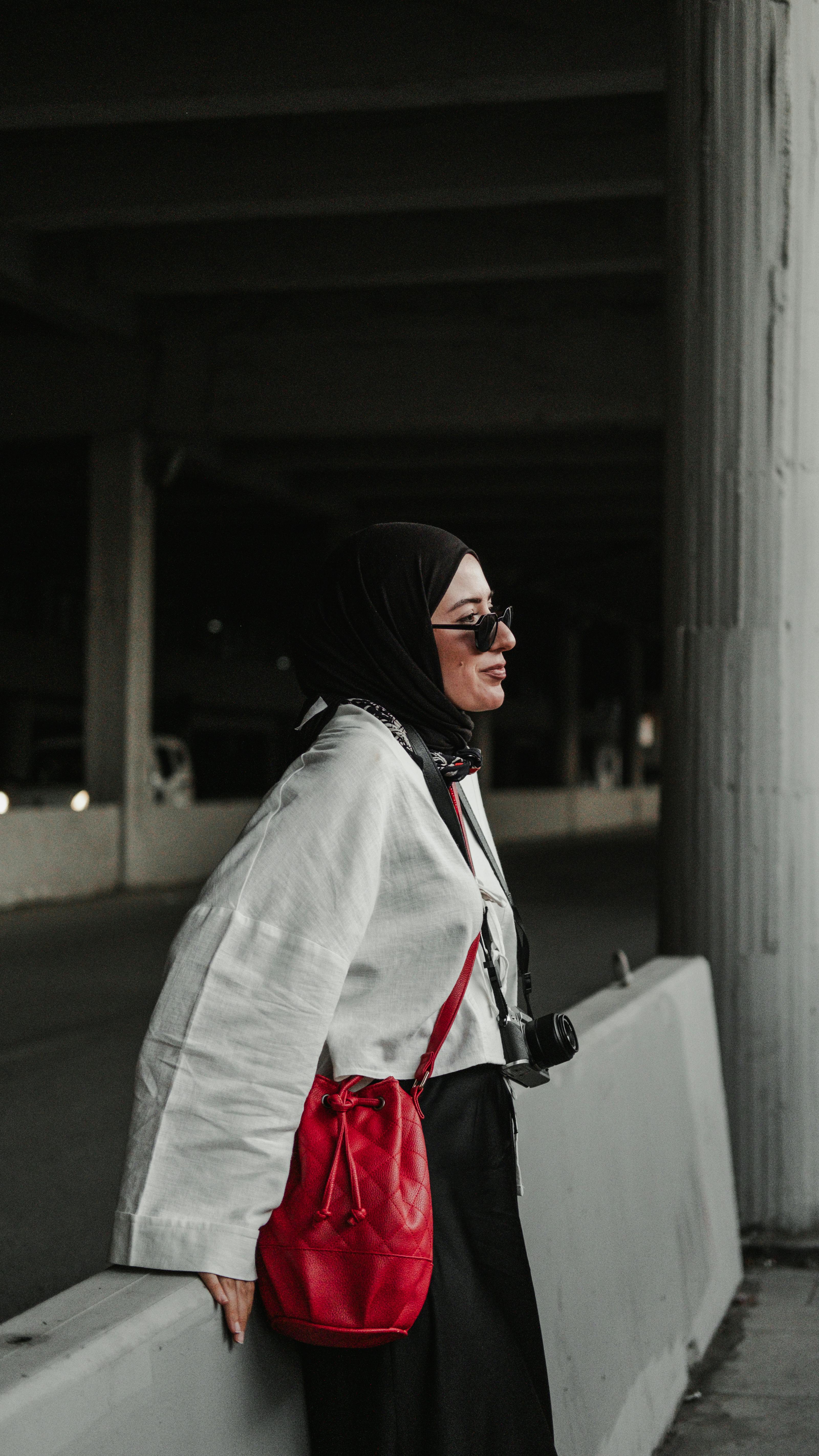 a woman in a hijab and a red bag