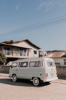 A classic van parked on a suburban street under a clear sky, evoking travel and nostalgia.