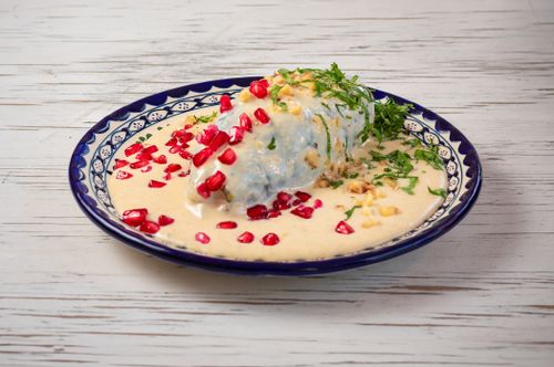 Free Delicious Chiles en Nogada, a classic Mexican dish, garnished with pomegranate seeds on a Talavera plate. Stock Photo