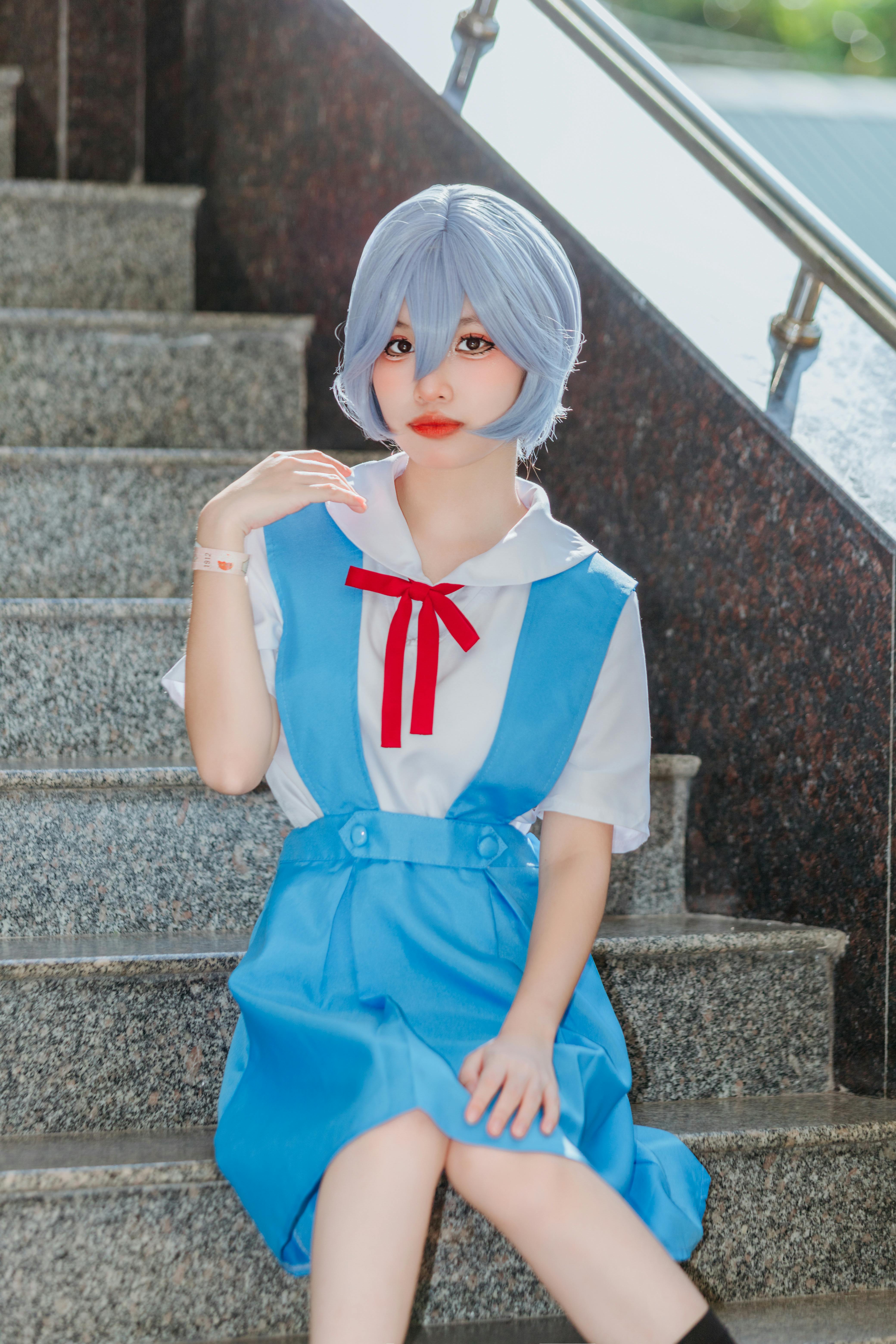a woman in a school uniform sitting on stairs