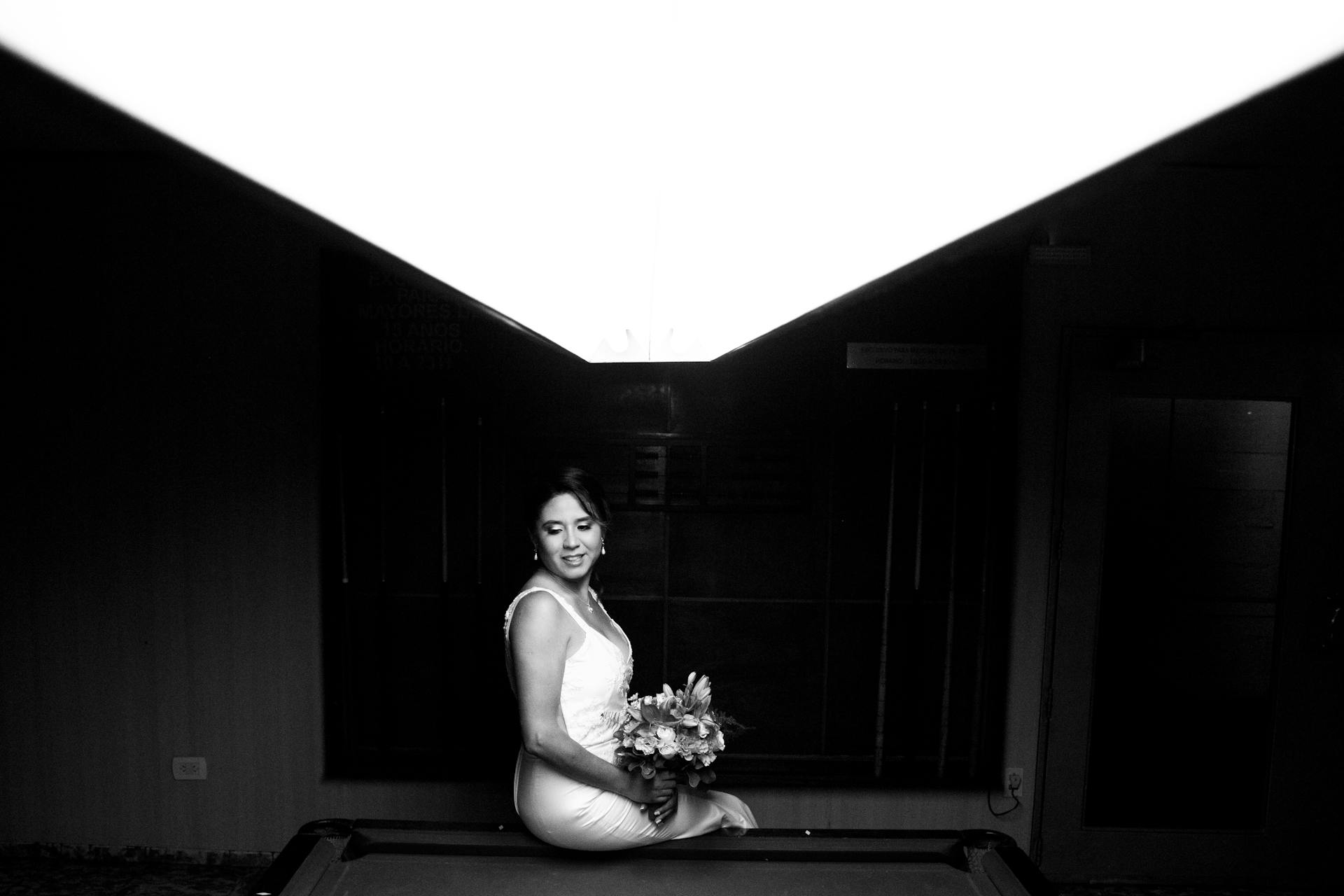 A bride sitting on a pool table in a dark room