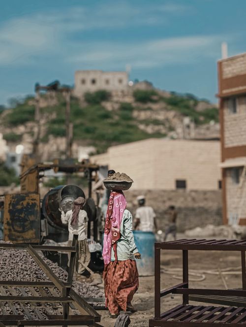 Free Construction workers at a rural site with traditional attire and equipment. Stock Photo
