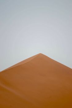 A tranquil and minimalist view of a sand dune peak in the desert, showcasing natural patterns and isolation.. pexels, tranqui