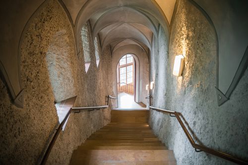 Free Discover a gothic staircase with arched ceilings leading to a window view. Stock Photo