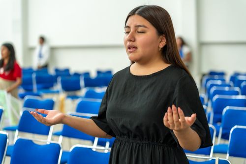 Free A woman in deep prayer inside an auditorium in Ciudad de México, representing faith and spirituality. Stock Photo