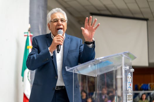 A politician delivers a passionate speech at an indoor public gathering in Mexico.