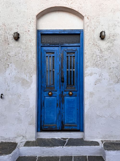 Free Blue painted door with traditional Greek island architecture in a rustic setting. Stock Photo