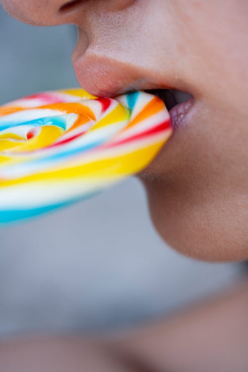 Person Eating Multi-colored Lollipop