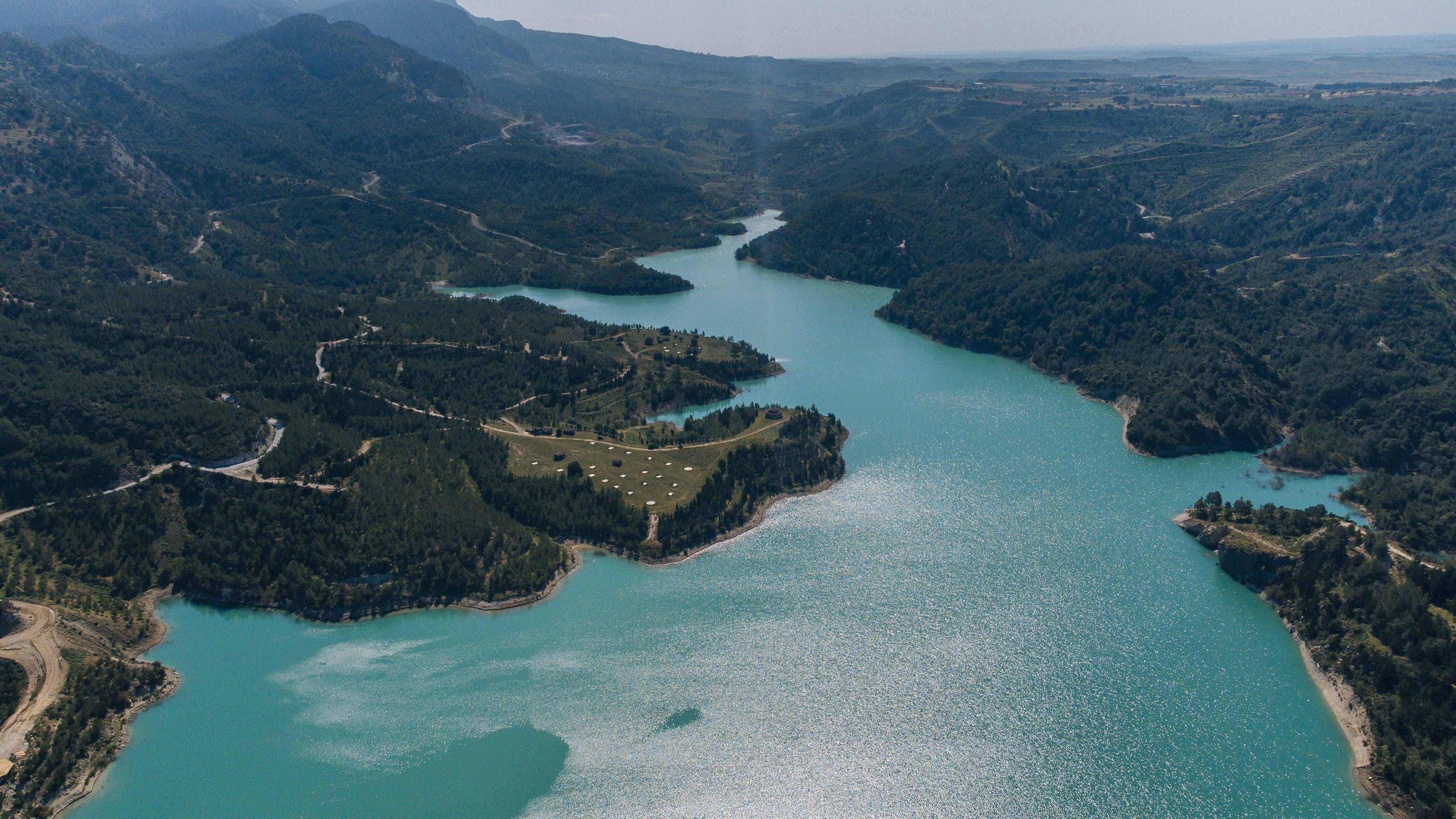A wild, turquoise river winding through a green valley, like Albania's Vjosa
