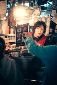 Engaging shot of vendor interacting with customers in a bustling Seoul market.