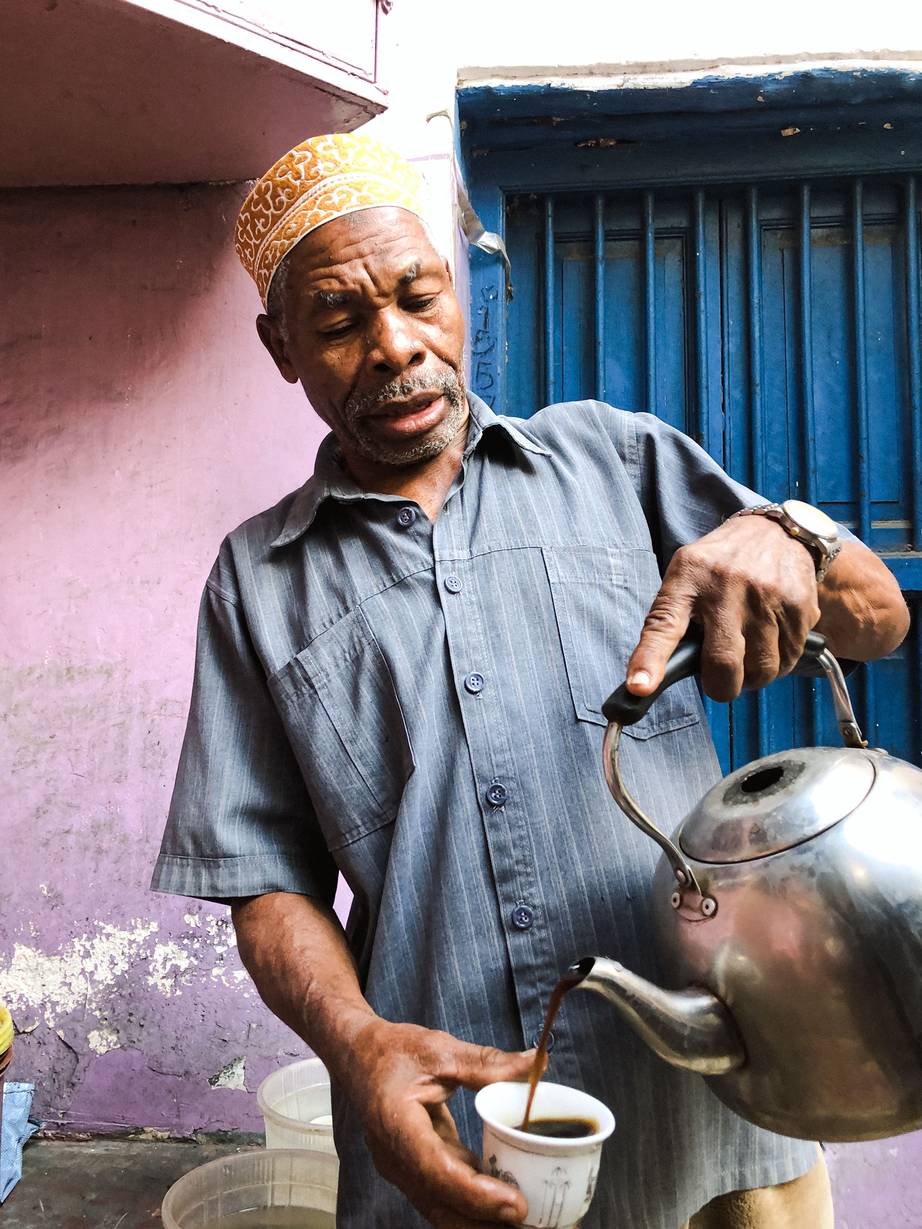 A man is pouring tea from a kettle · Free Stock Photo