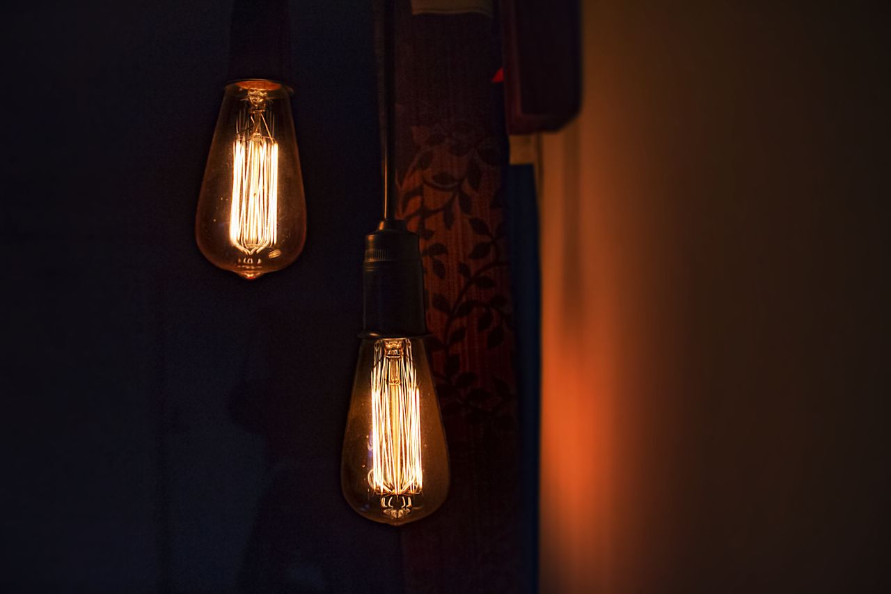 two vintage edison bulbs glowing warmly indoors creating an atmospheri