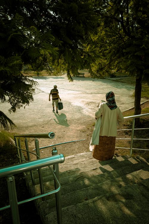 Free Two adults walking in a sunny park in Adana, Türkiye, capturing serene leisure time outdoors. Stock Photo