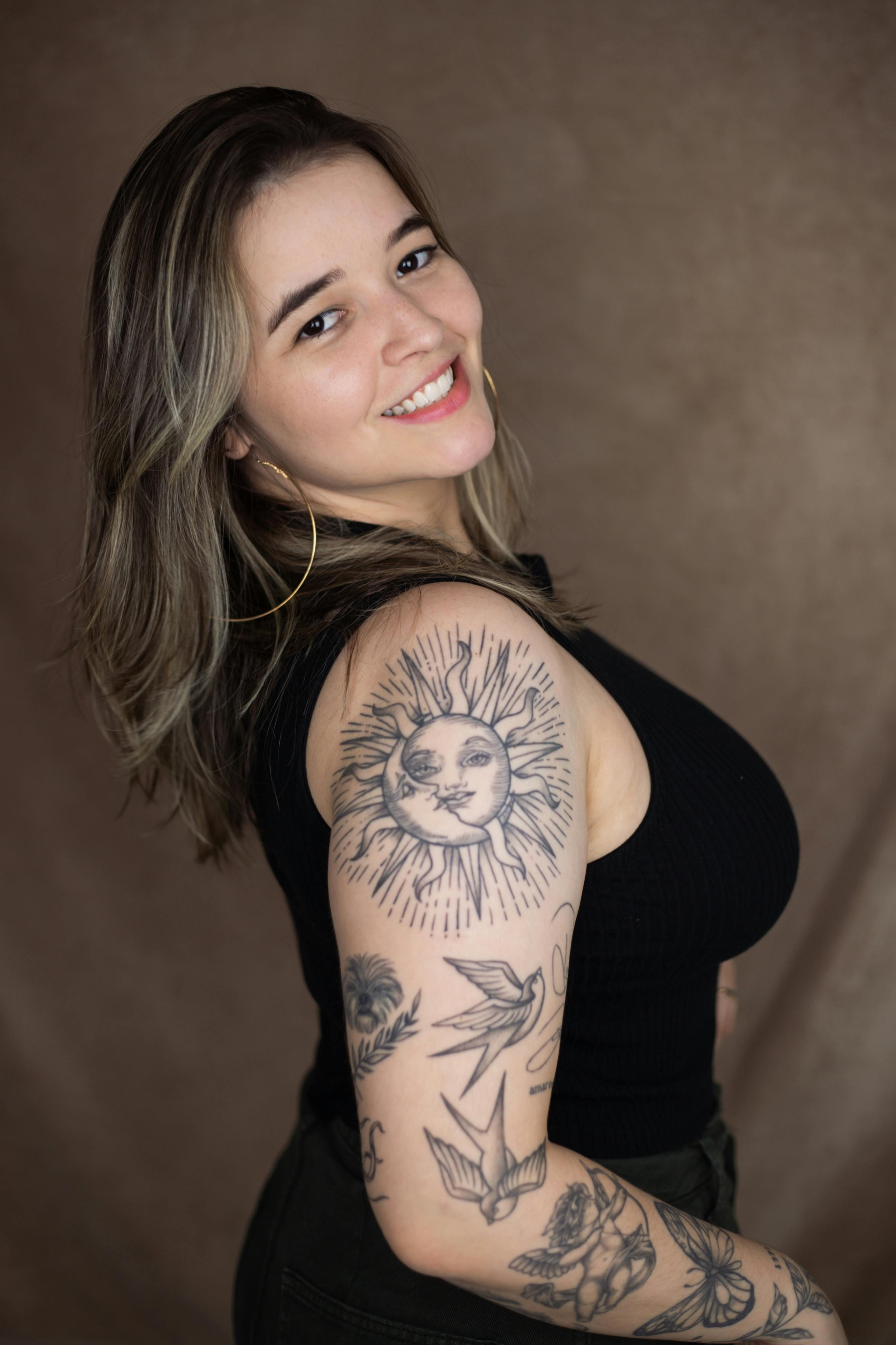 a woman with tattoos on her arm posing for a photo