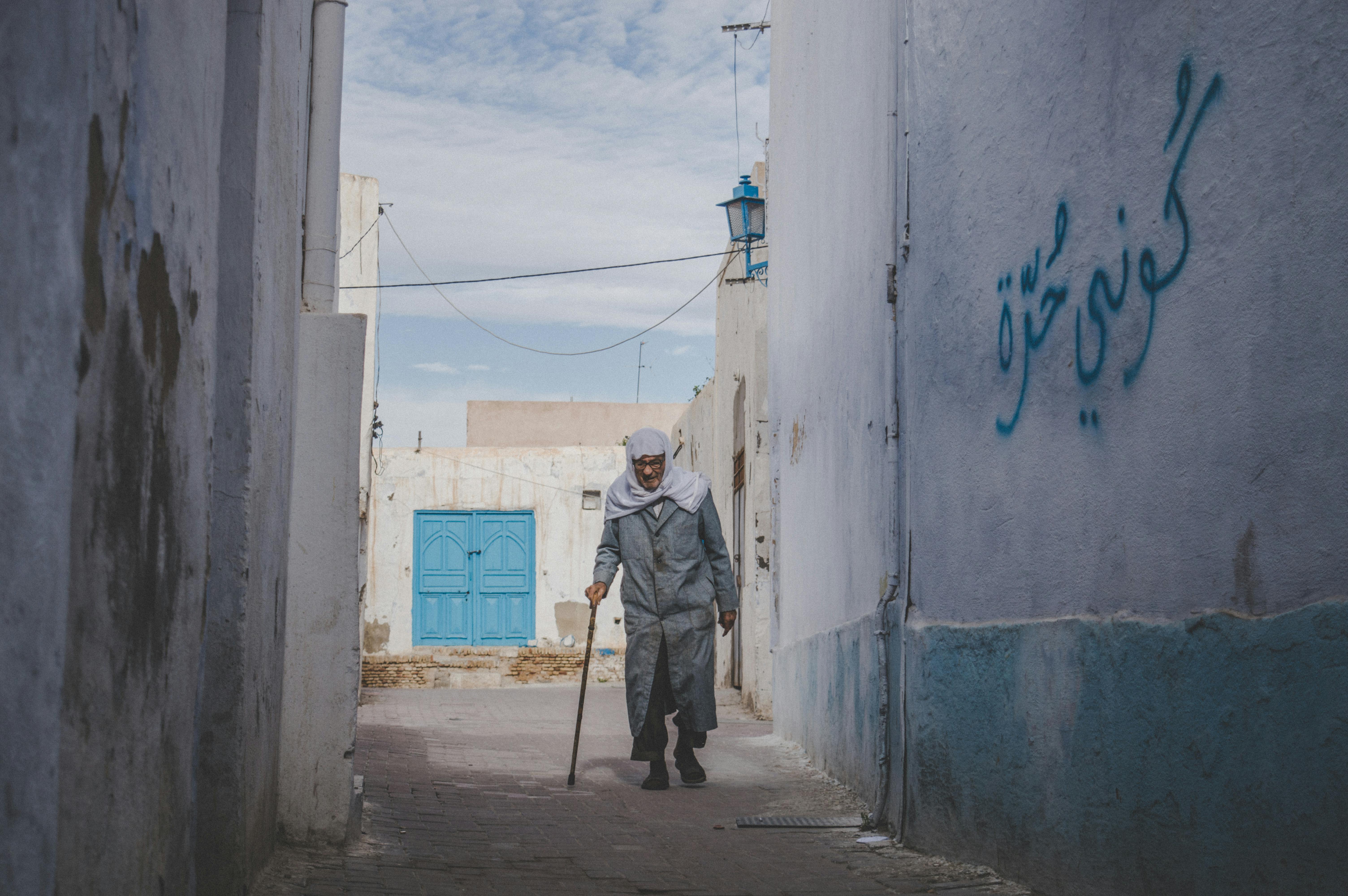 Homme âgé dans une ruelle de la médina tunisienne, scène de vie locale