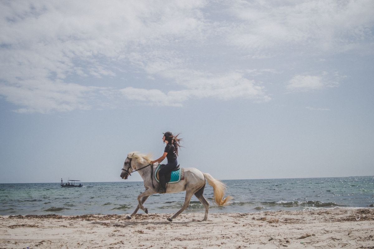 A rider cantering along a sandy Atlantic beach on Ireland's west coast
