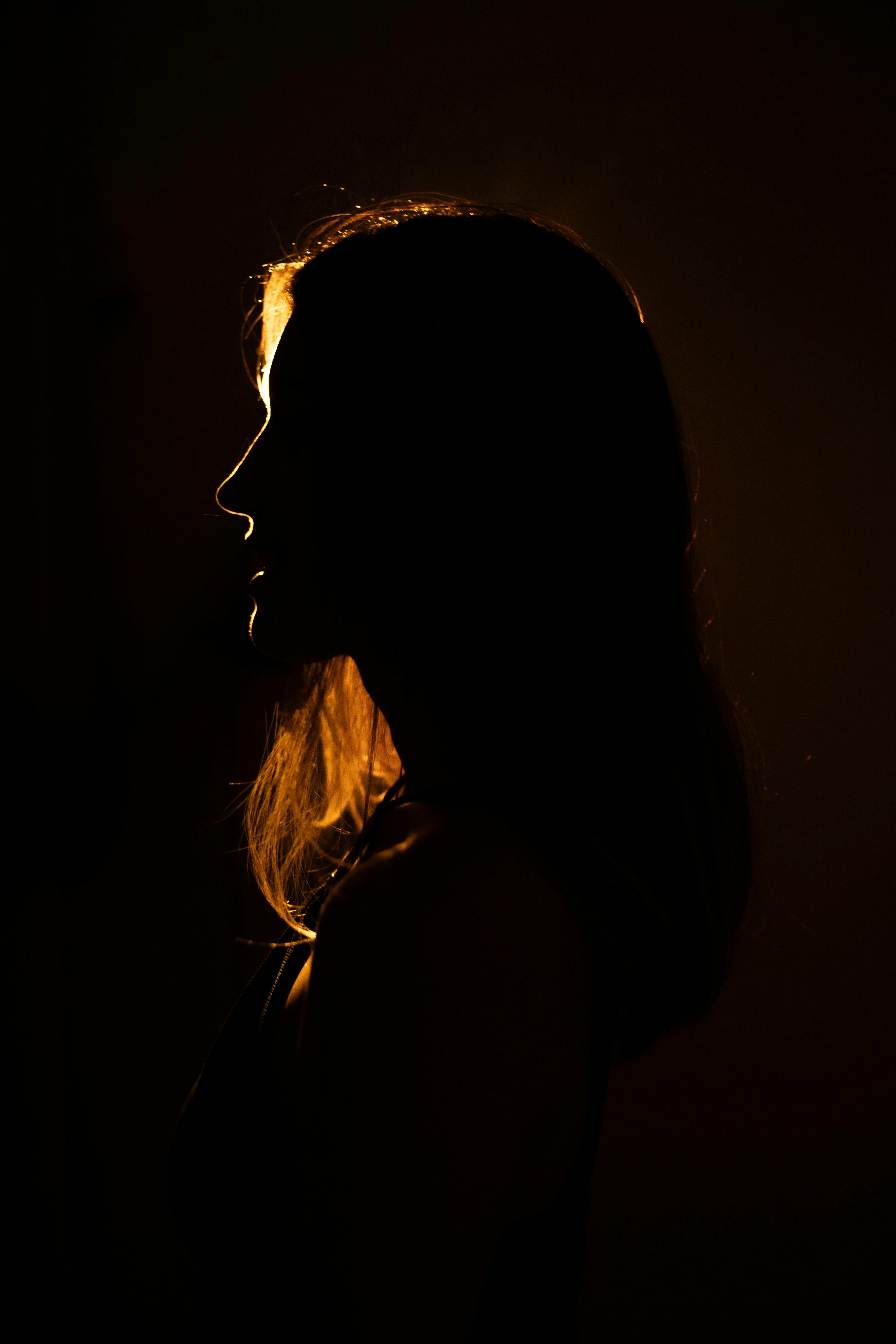 a woman in silhouette in the dark