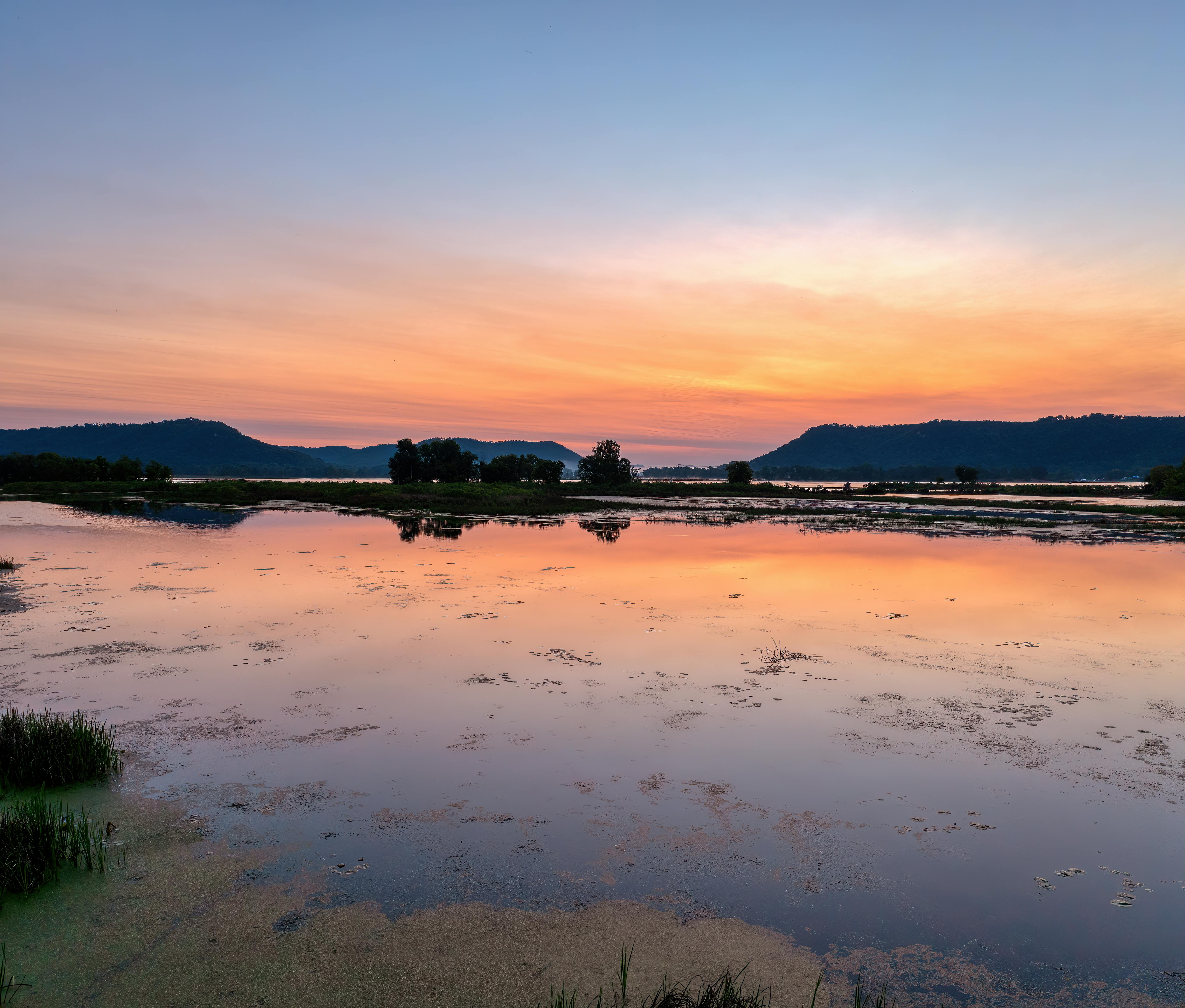 Beautiful sunrise reflecting over a tranquil lake in Wabasha, Minnesota, showcasing serene nature.
