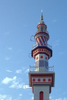 Vividly decorated minaret standing tall against a clear blue sky in Punjab, Pakistan.