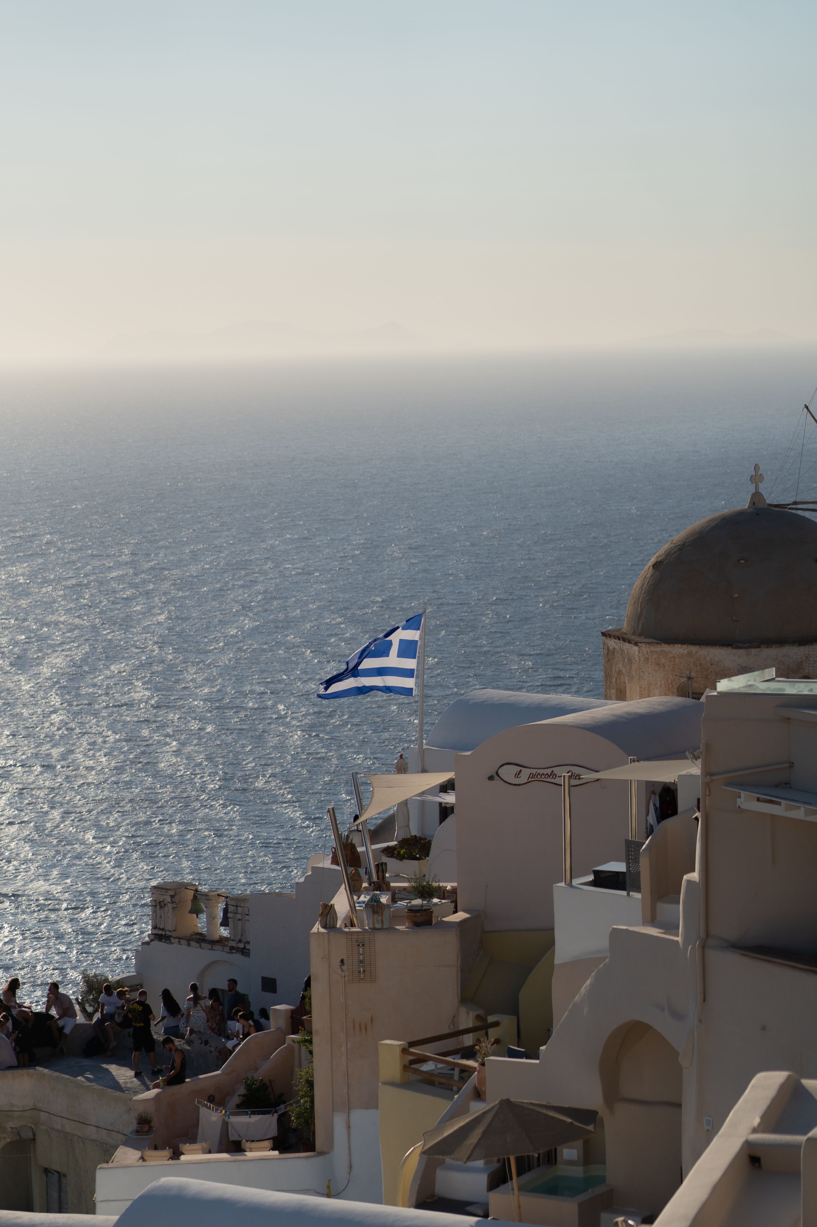 A view of a beach with a greek flag flying · Free Stock Photo