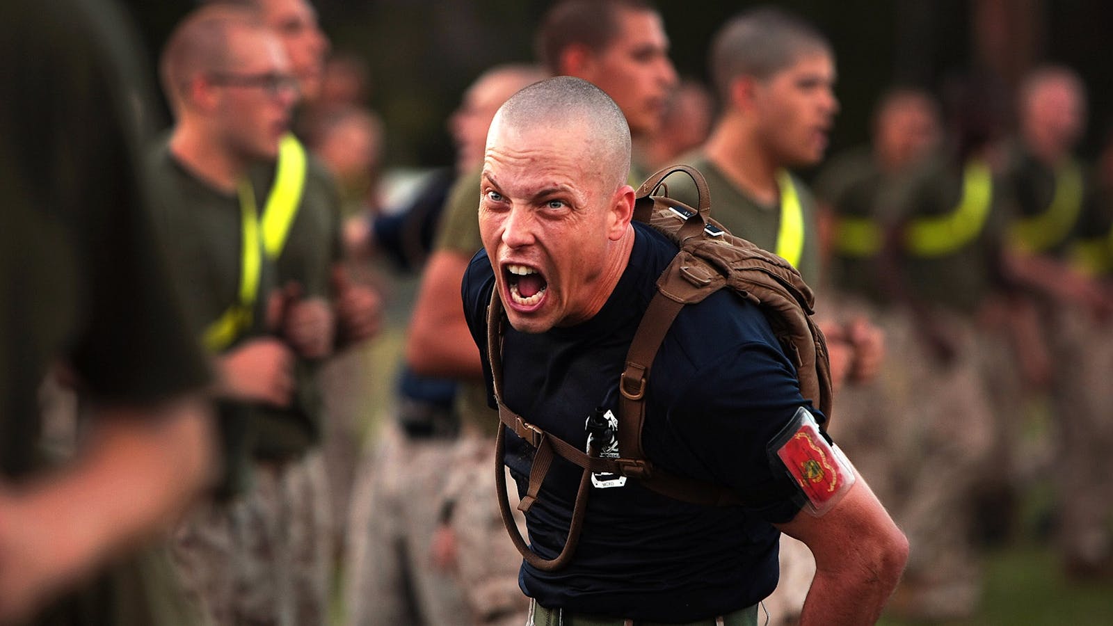 man wearing brown backpack yelling.