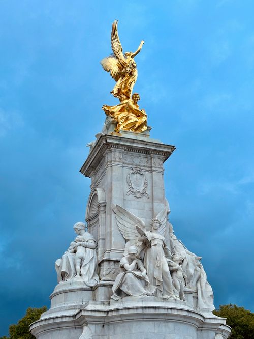Free Majestic Victoria Memorial statue in London with gleaming gold sculptures against a vibrant blue sky. Stock Photo