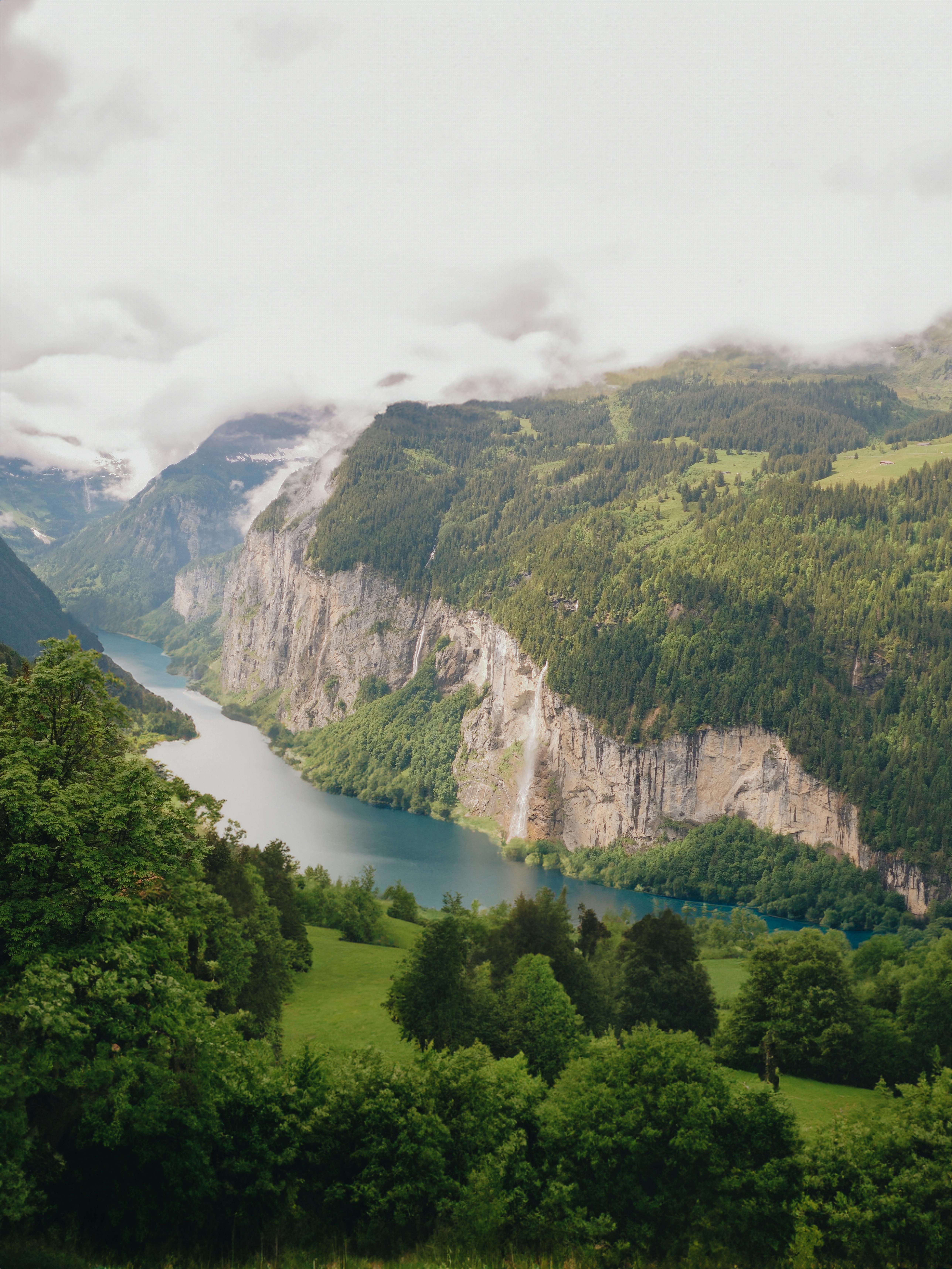 a view of a valley with mountains and water