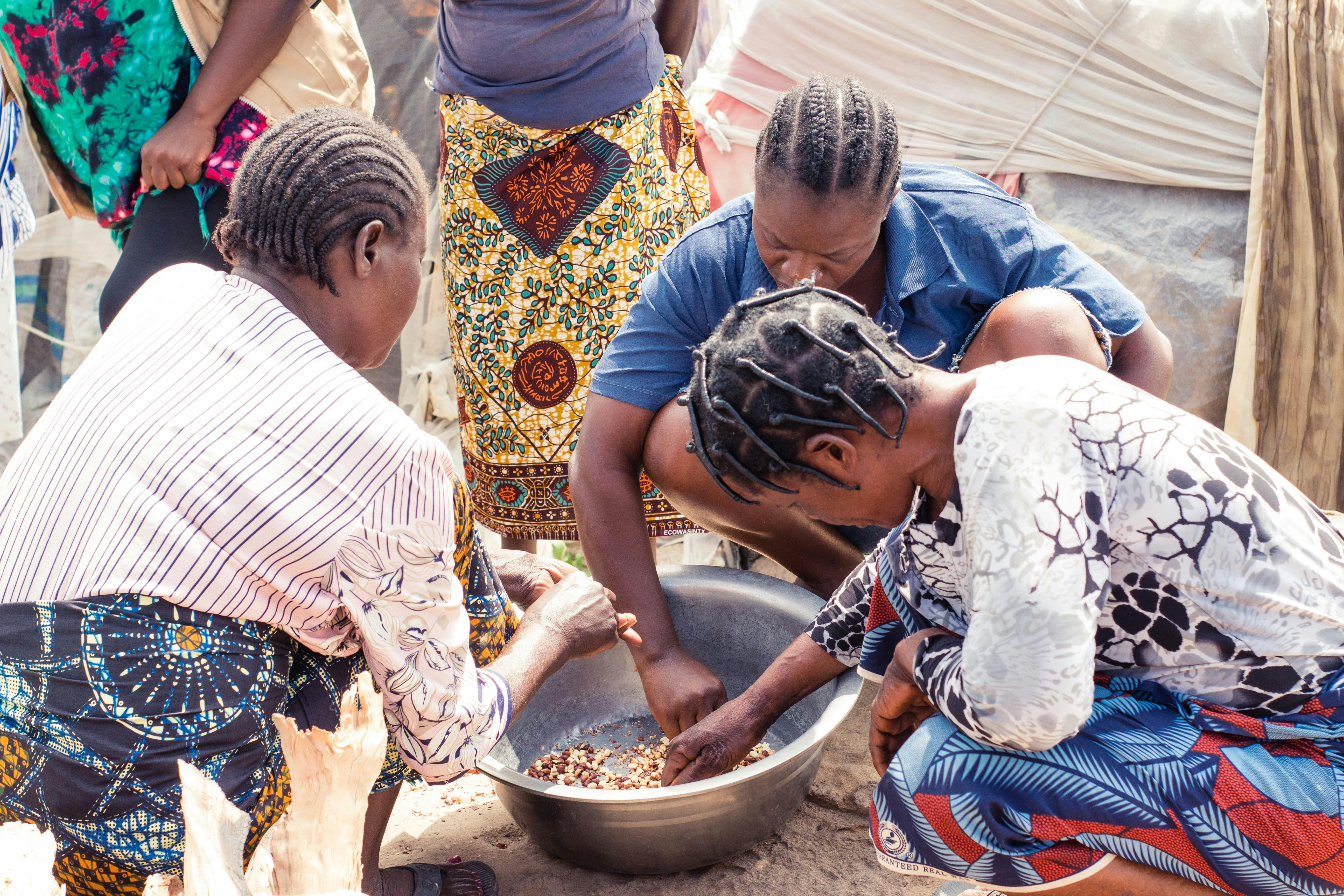 a group of women are cooking food in a bowl