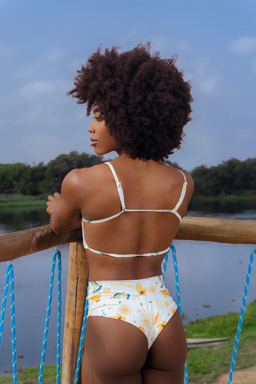 Free A woman in a bikini stands by a lake, enjoying the outdoor scenery. Stock Photo