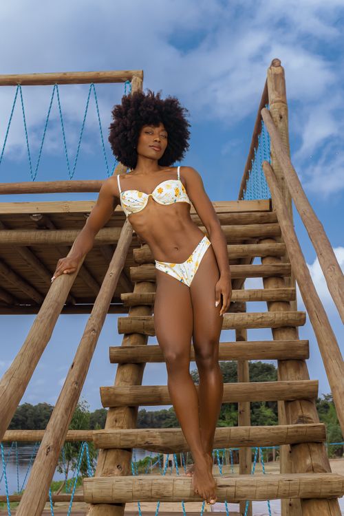 Free Confident young woman in bikini on rustic outdoor staircase embodying summer vibes. Stock Photo