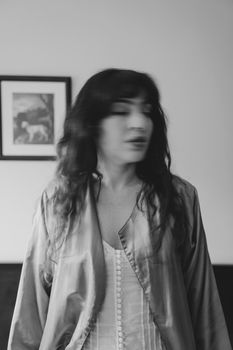 Artistic black and white portrait of a woman in a satin robe.