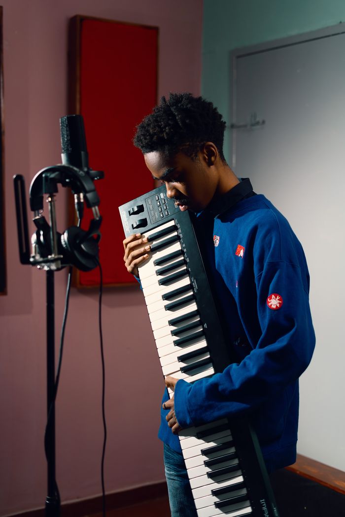 A musician holding a keyboard in a studio — Kaiser Leo Xiv on Pexels