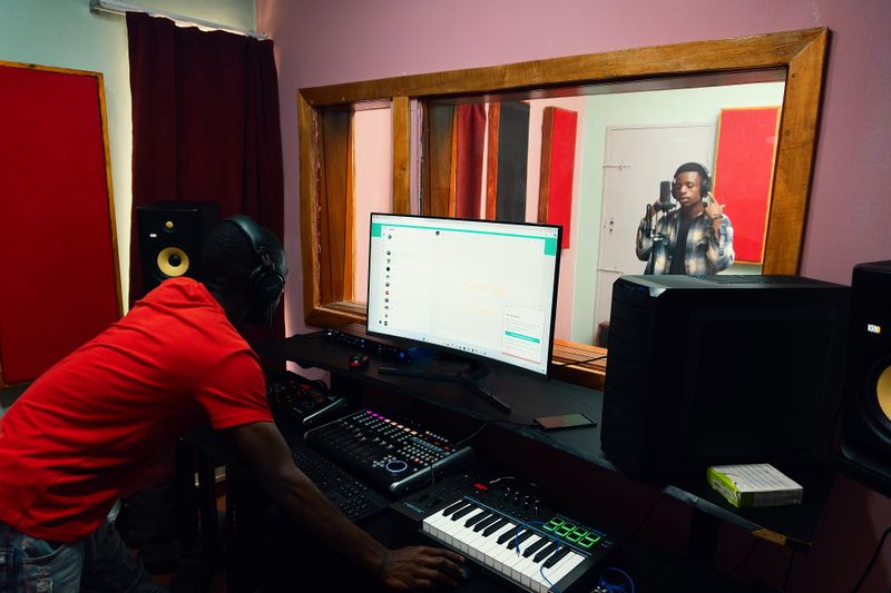 Music producer and singer collaborating inside a professional recording studio
