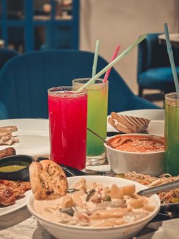 A vibrant dining setup in Kolkata showcasing colorful drinks and delicious Indian cuisine.