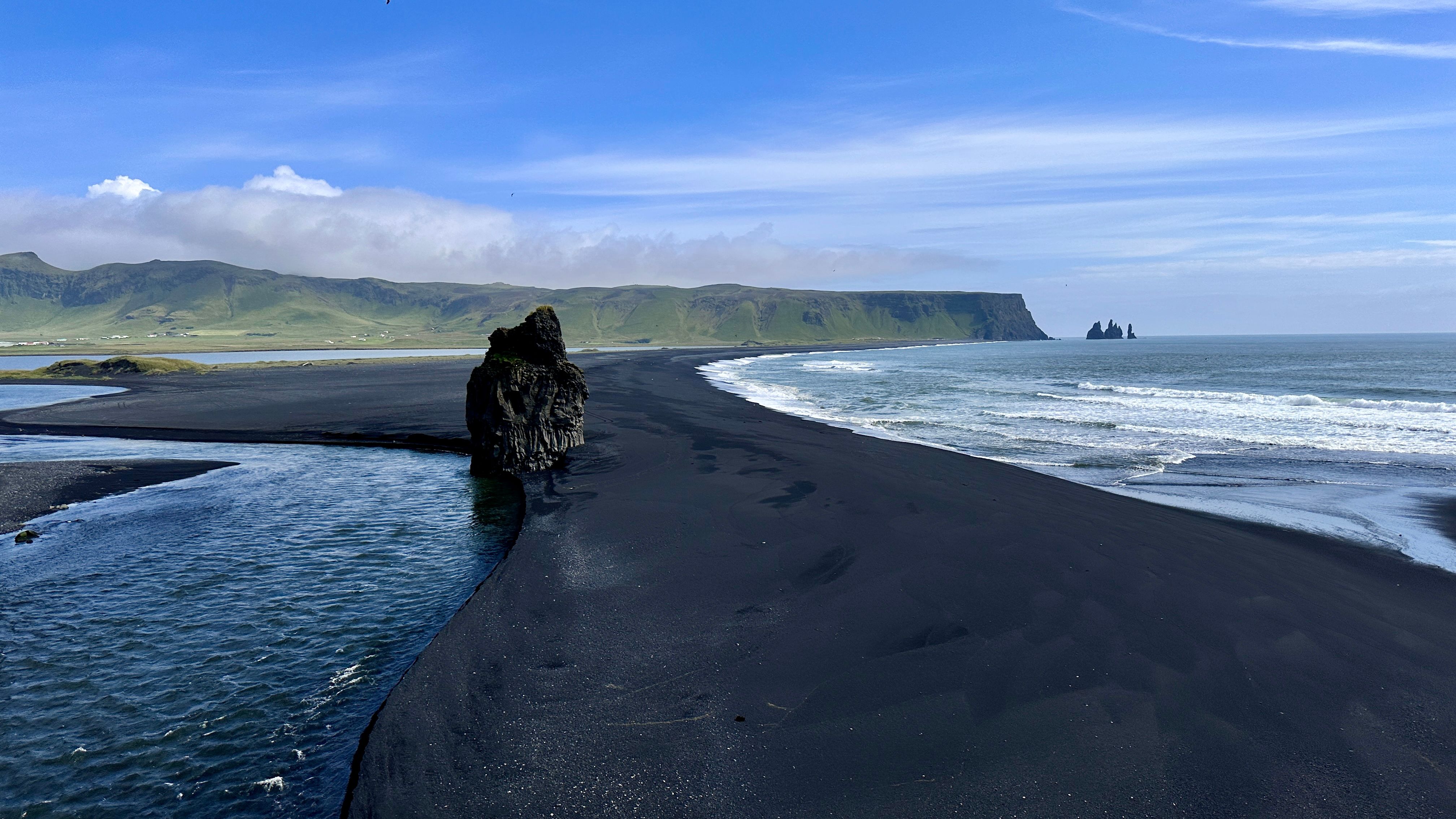 Stunning view of Reynisfjara's black sand beach and sea stacks in Iceland.