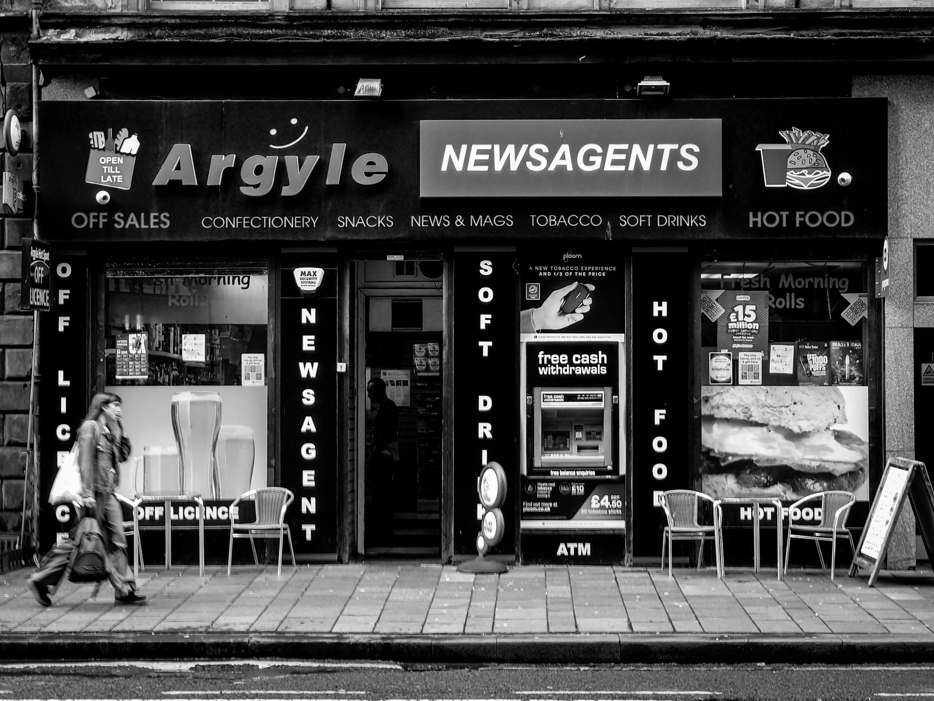 Exterior of Argyle Newsagents on a bustling Glasgow street in black and white.