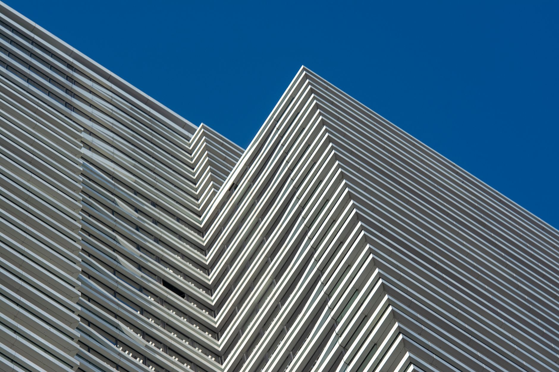 Angular view of a modern skyscraper facade in Den Haag, showcasing futuristic architecture.