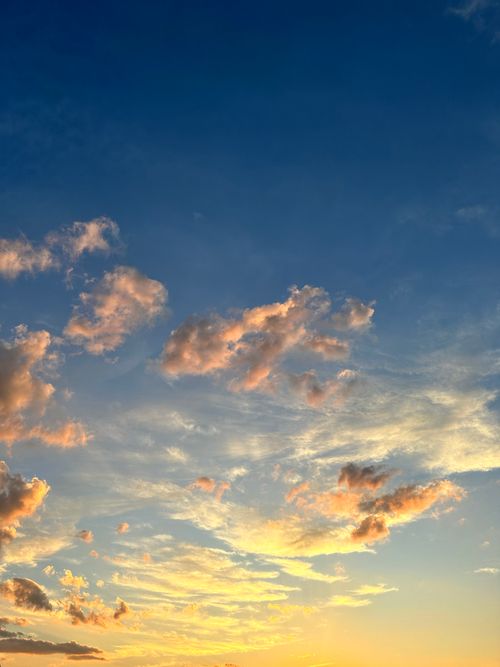 Free A beautiful sunset sky with dramatic clouds and golden hues, capturing the tranquility of nature. Stock Photo