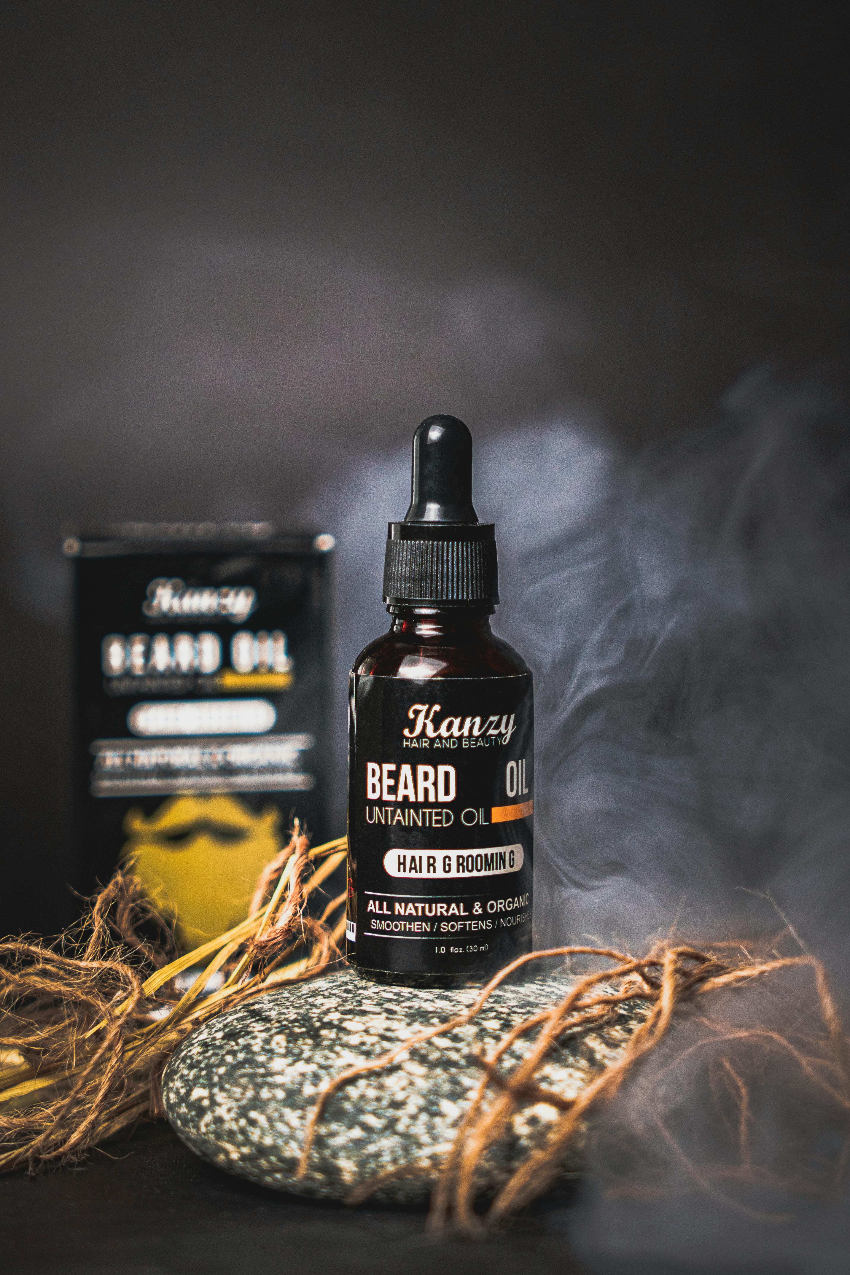 A stylish bottle of beard oil on a textured surface with smoke creating a luxurious and natural ambiance.