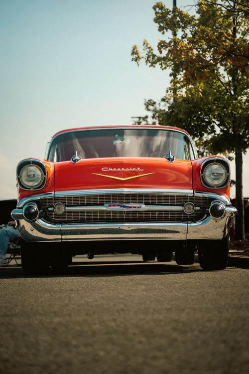 Free Front view of a classic red Chevrolet Bel Air parked outdoors under clear skies. Stock Photo