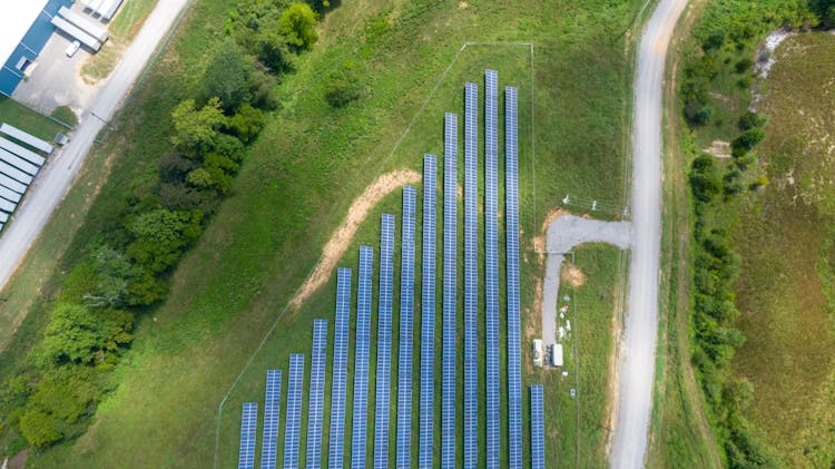 Aerial View Of Solar Panels Array On Green Grass