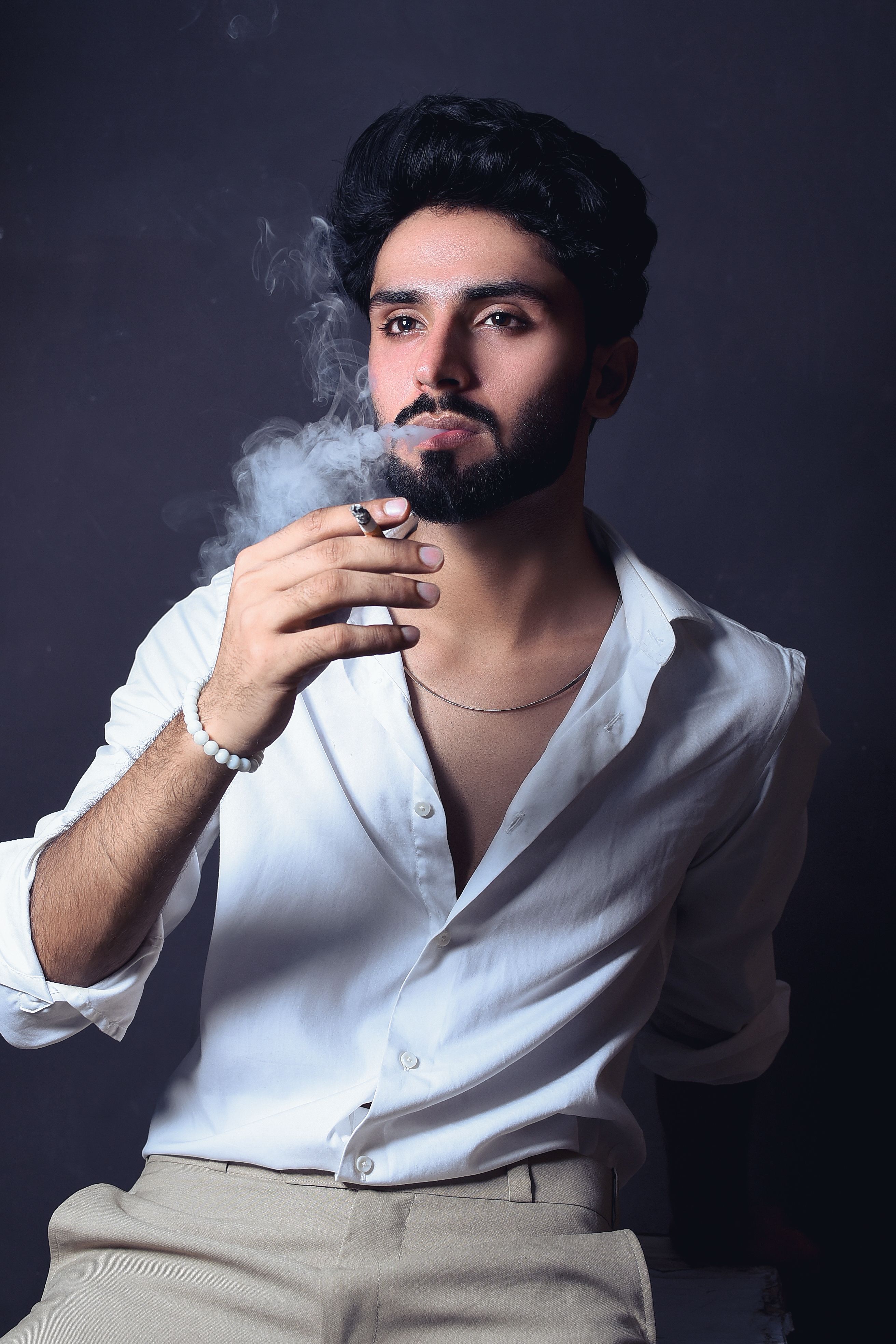Artistic portrait of a stylish man smoking, exuding sophistication and contemplation.