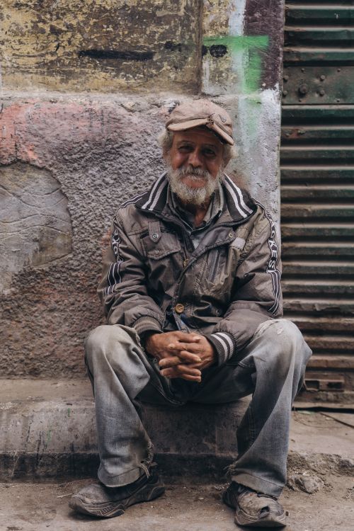 Free Portrait of an elderly man sitting on a street in Alexandria, Egypt, capturing the essence of urban life. Stock Photo
