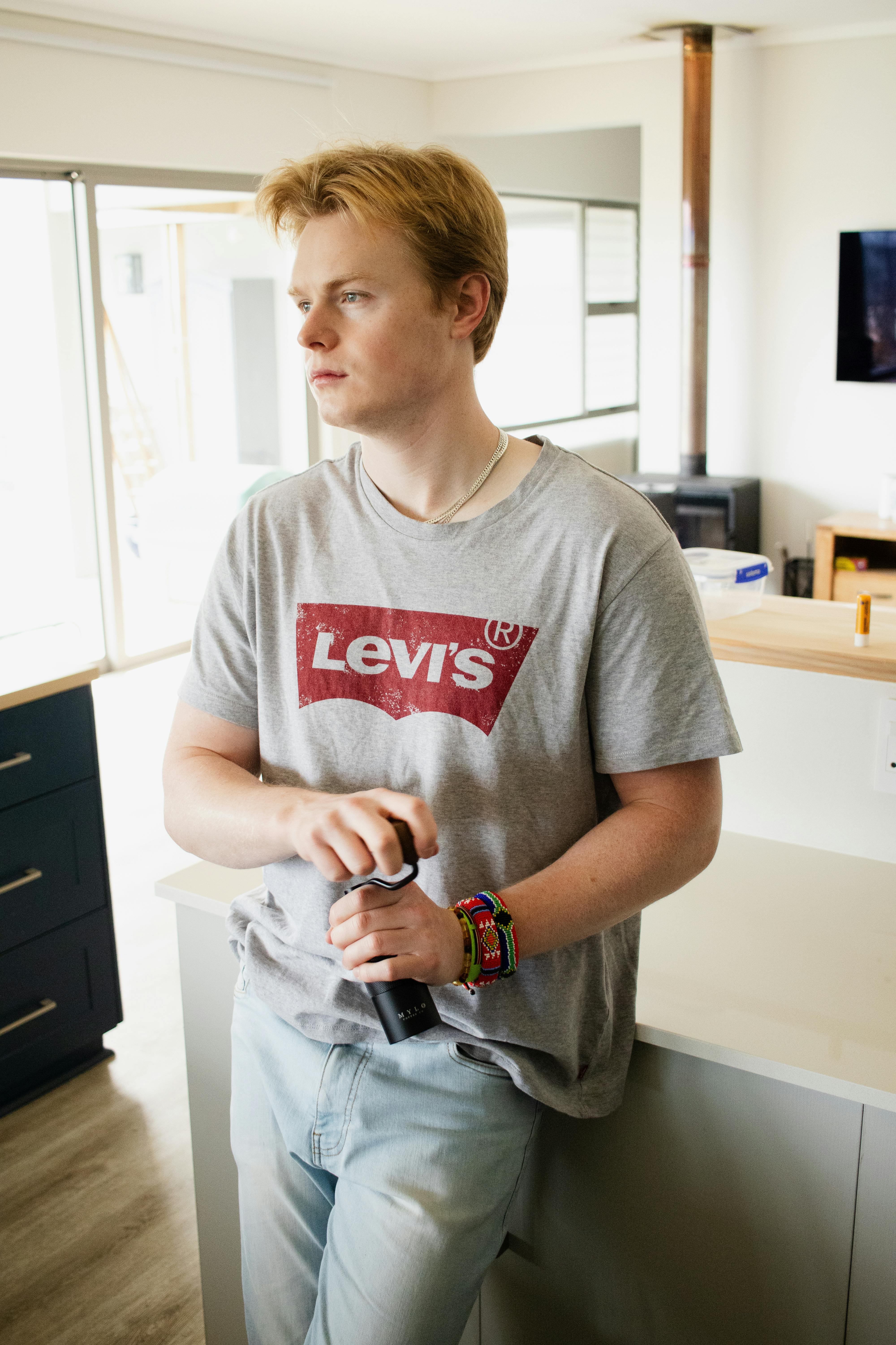 a young man is standing in a kitchen